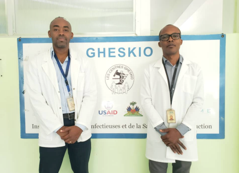 Image: Dr Reichling St Sauveur (left) and Dr Rodney Sufra (right) post in front of the GHESKIO logo